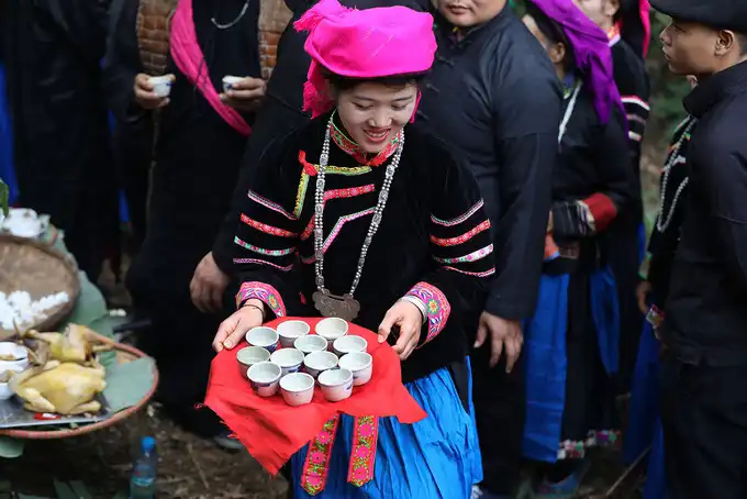 Pu Peo women hand cups of wine to the attendees to mark the end of the ceremony.